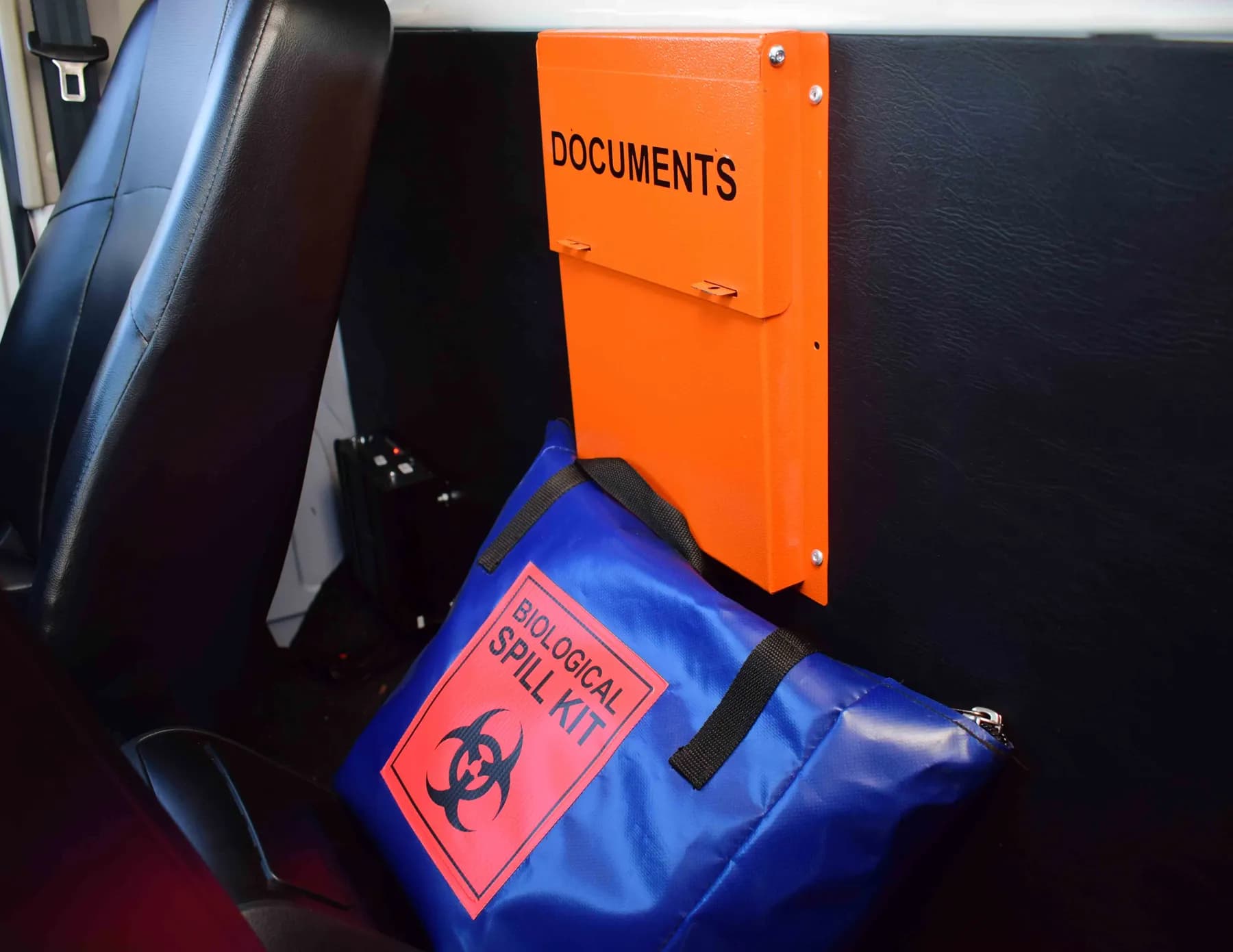Biohazard spill kit and documents box behind the seat