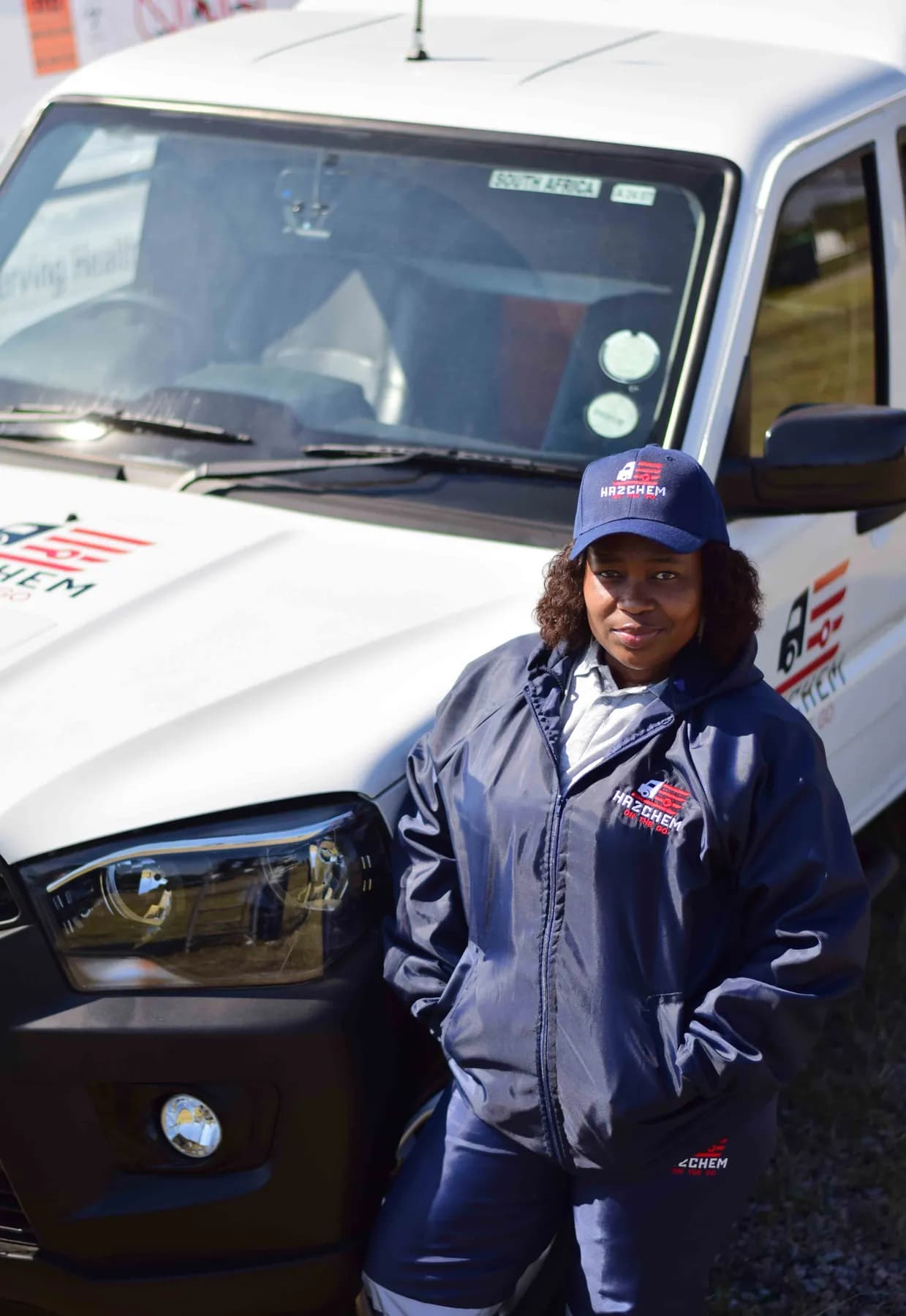 Hazchem crew member in uniform beside a branded vehicle