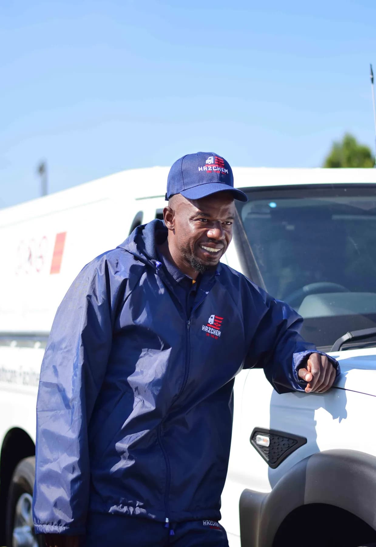 Hazchem crew member in uniform beside a branded vehicle