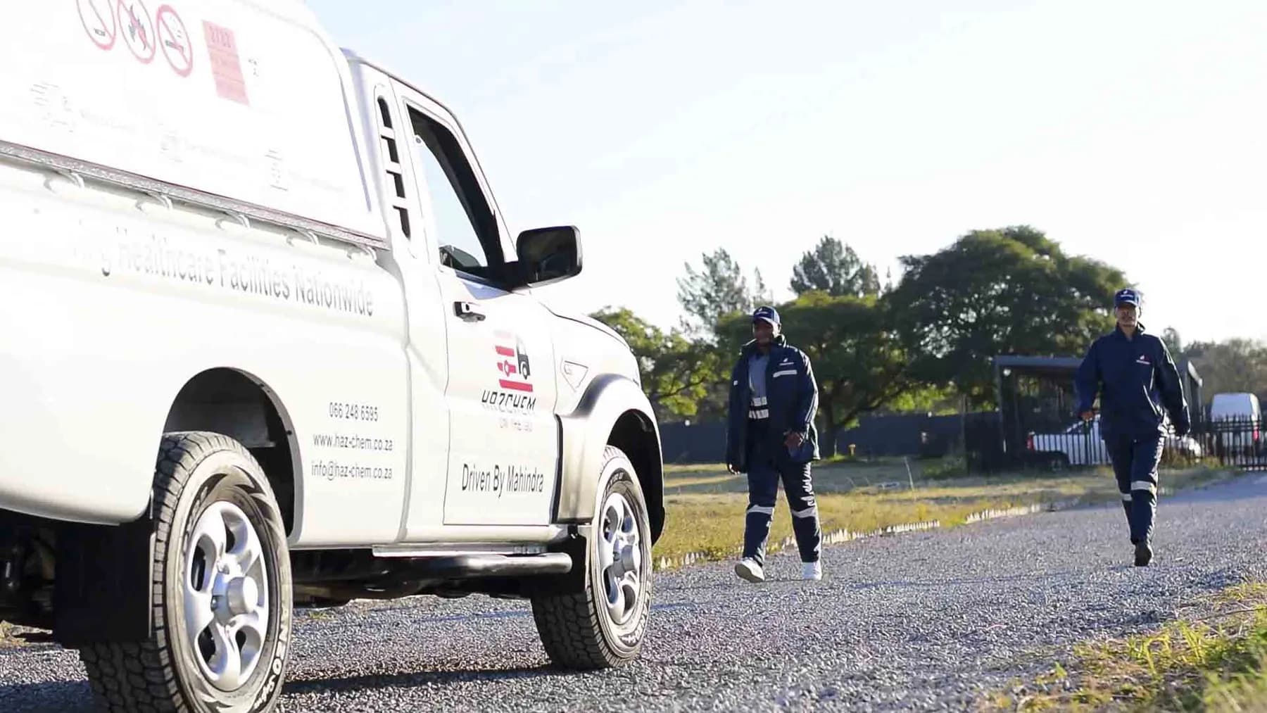 Hazchem bakkie with crew walking to a delivery