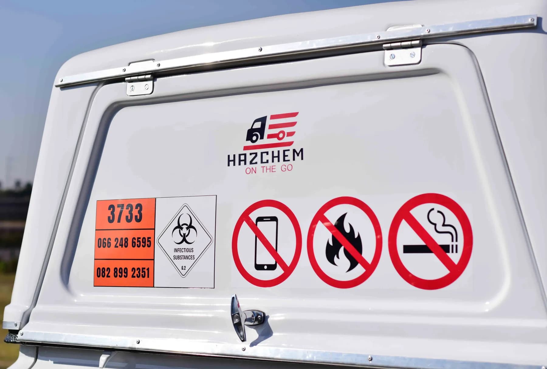 UN3373 and dangerous-goods placards on a Hazchem canopy