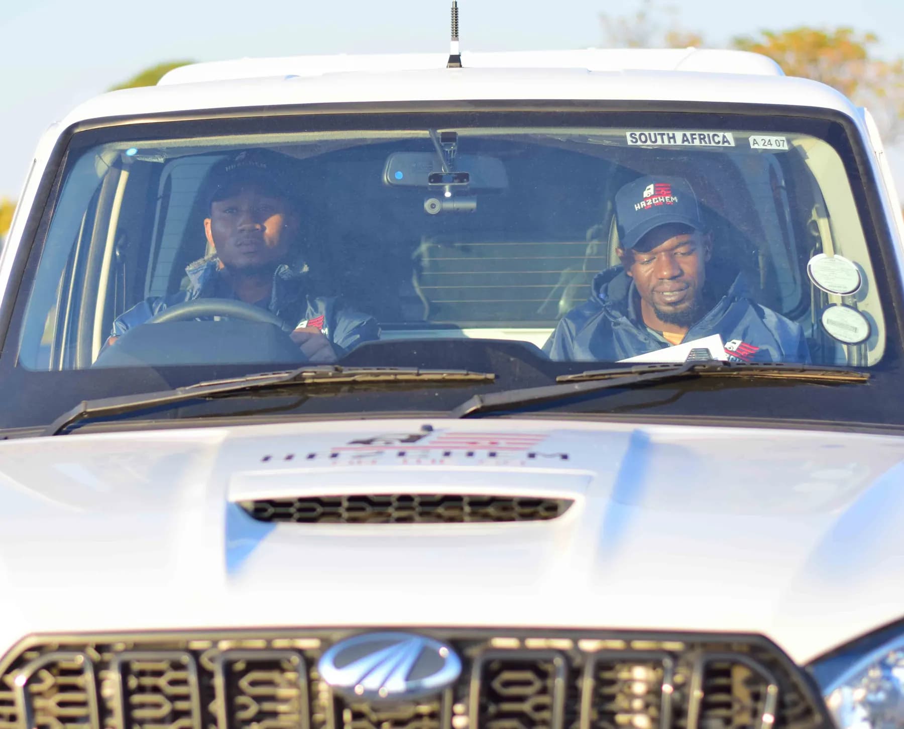 Two crew members in the cab of a Hazchem bakkie