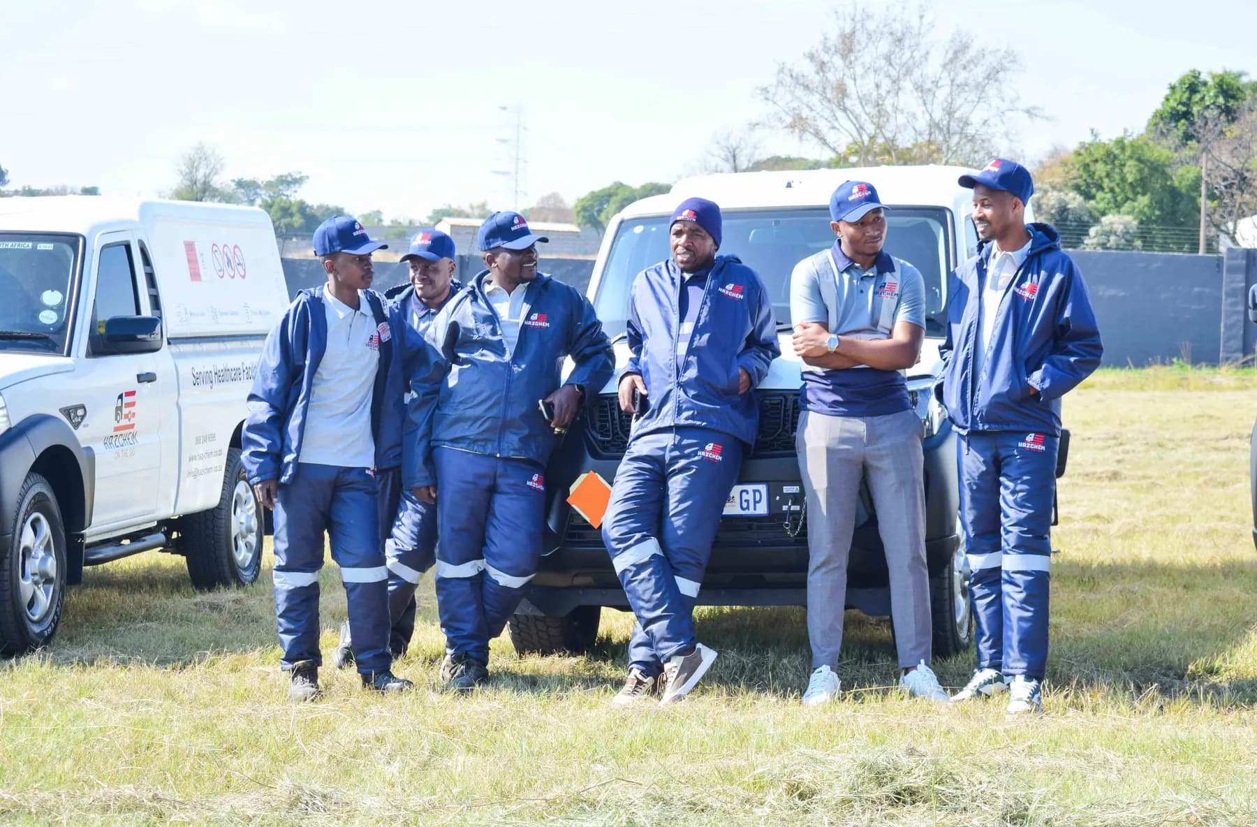 Hazchem crew members in navy uniforms beside their vehicle